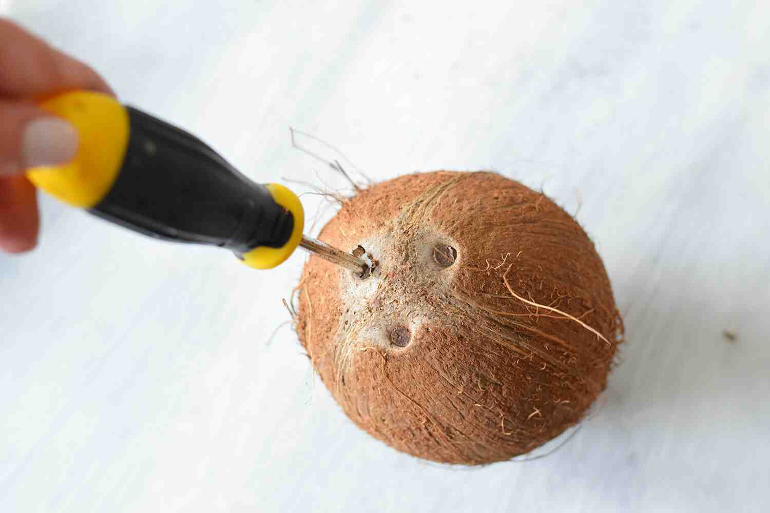 How do you poke a hole in a coconut?